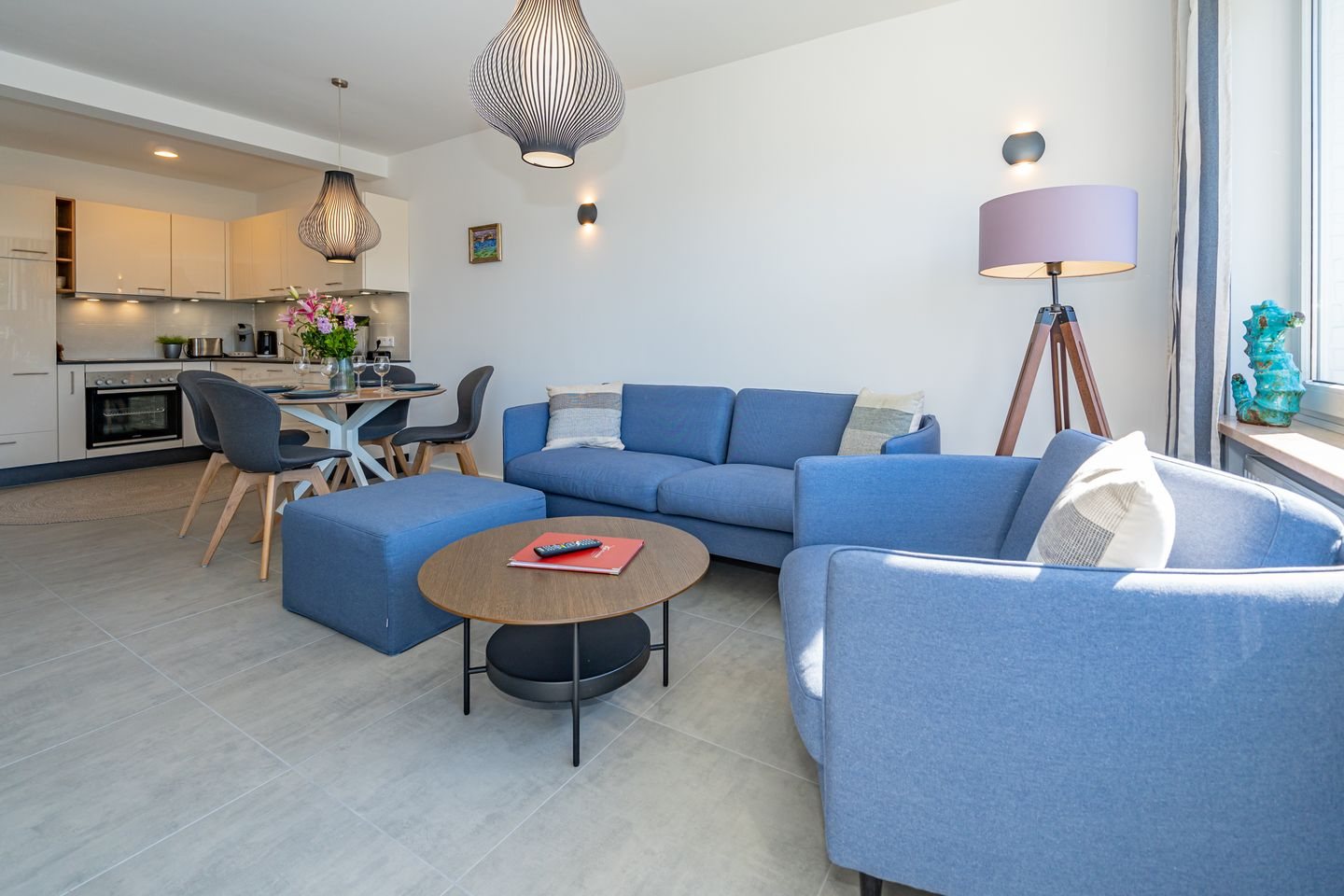 Offener Wohnbereich mit blauem Sofa und Essplatz